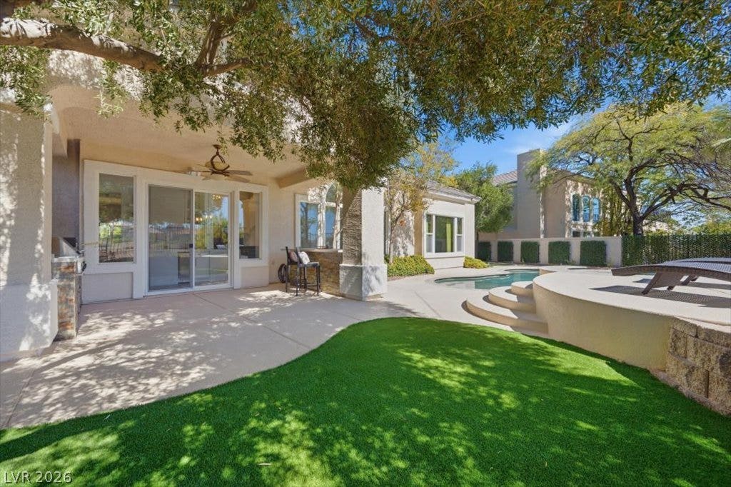 9521 Queen Charlotte Drive, Las Vegas, NV 89145 Mature trees shade a spacious patio bordering a manicured lawn and private pool.