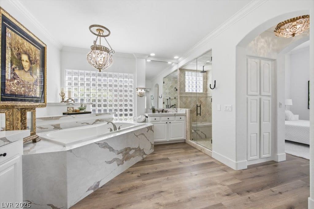 9521 Queen Charlotte Drive, Las Vegas, NV 89145 A glass-enclosed shower, dual vanities, and a soaking tub define this elegant bathroom.