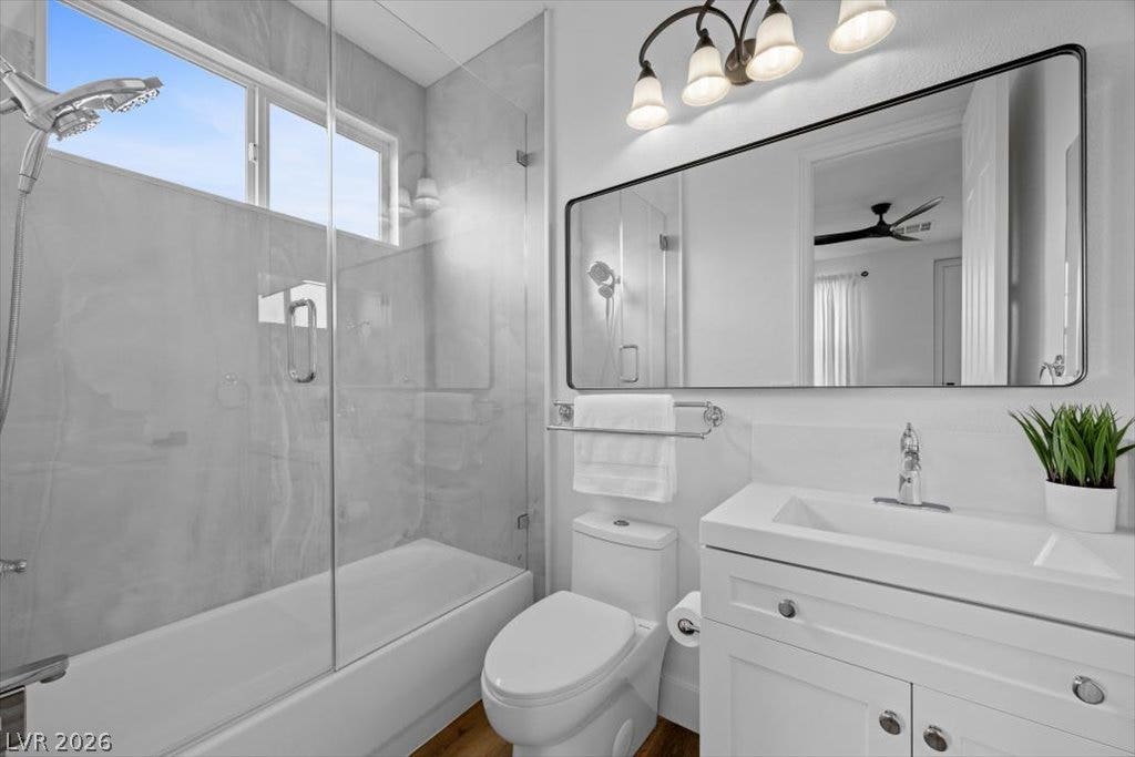 9521 Queen Charlotte Drive, Las Vegas, NV 89145 A glass-enclosed shower and tub pairing features tiled walls alongside a white single vanity setup.