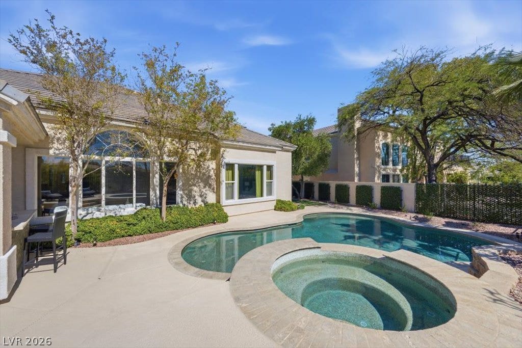 9521 Queen Charlotte Drive, Las Vegas, NV 89145 An inviting backyard oasis features a curved swimming pool and matching integrated spa.