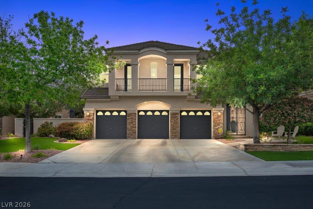 9521 Queen Charlotte Drive, Las Vegas, NV 89145 Stately stucco and stone architecture frames this double-level exterior with three garage bays.