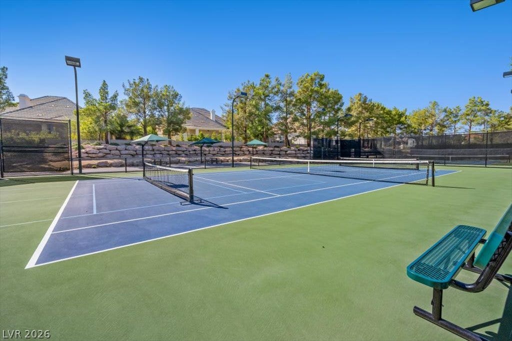 9521 Queen Charlotte Drive, Las Vegas, NV 89145 Professional-grade courts are surrounded by mature trees under a clear blue sky.