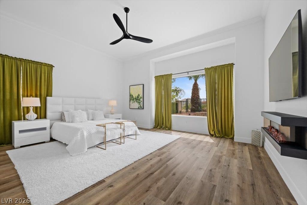 9521 Queen Charlotte Drive, Las Vegas, NV 89145 Warm wood floors and soaring ceilings define this airy bedroom space with a modern fireplace.