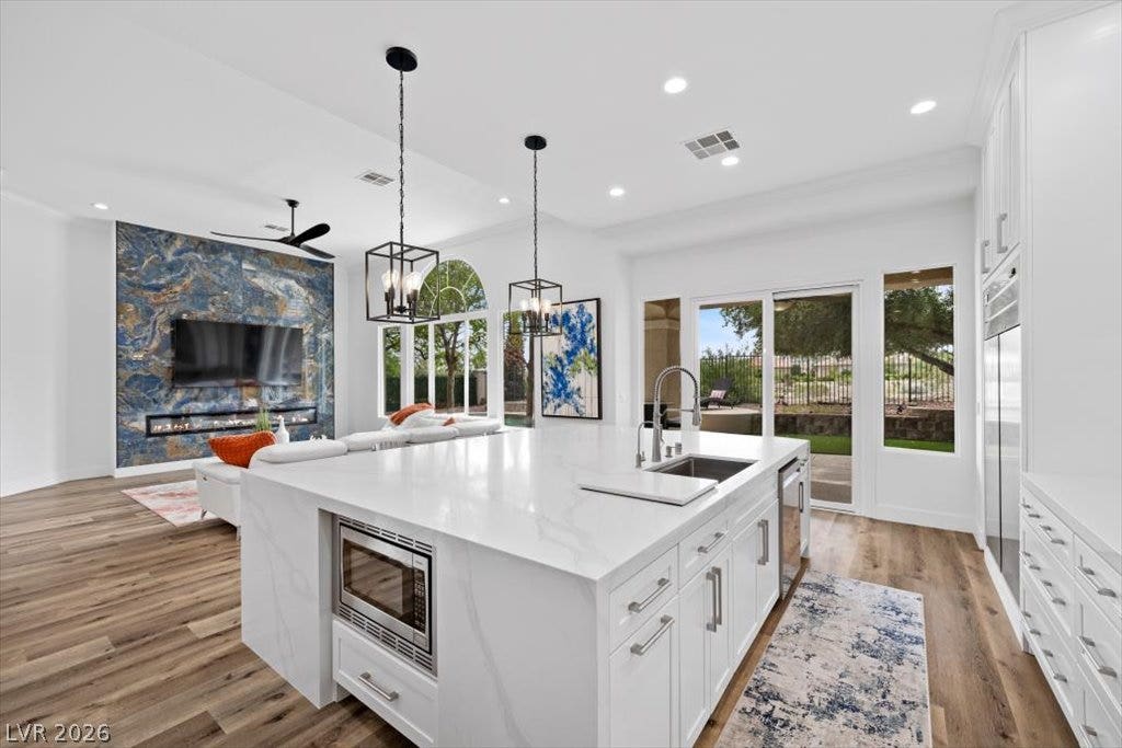 9521 Queen Charlotte Drive, Las Vegas, NV 89145 Gleaming stone countertops and warm wood floors define this airy open-concept space.