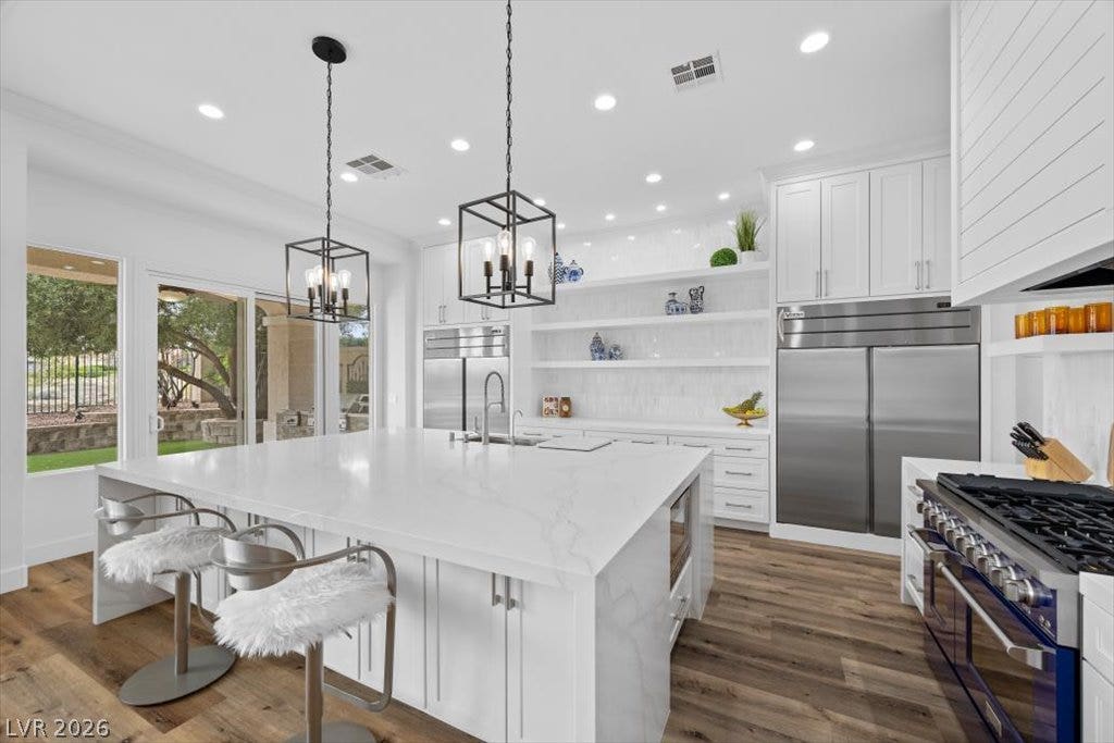 9521 Queen Charlotte Drive, Las Vegas, NV 89145 An expansive central island with waterfall stone counters anchor this light-filled culinary space.