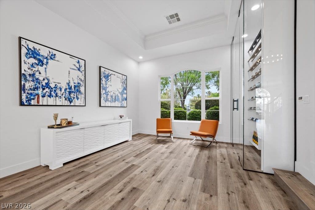 9521 Queen Charlotte Drive, Las Vegas, NV 89145 Rich wood-look flooring and a recessed tray ceiling define this versatile formal space.