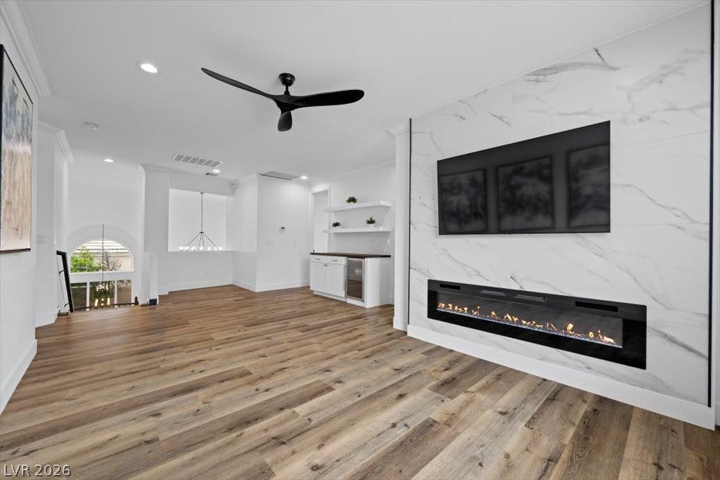 9521 Queen Charlotte Drive, Las Vegas, NV 89145 Rich wood floors anchor this open space featuring a modern linear fireplace with stone surround.