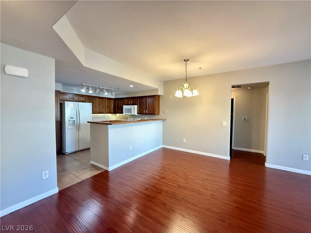 8777 W Maule Avenue, #1094, Las Vegas, NV 89148 Rich wood-inspired floors and a raised breakfast bar anchor this open dining space.