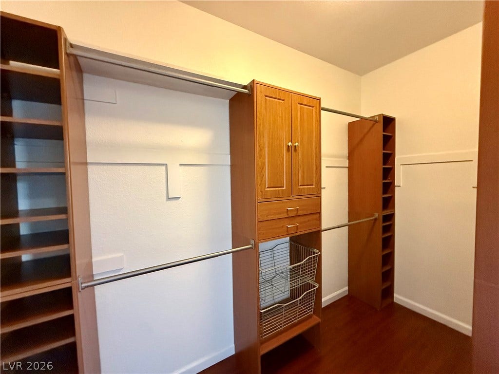 8777 W Maule Avenue, #1094, Las Vegas, NV 89148 Custom wood organization systems elevate this spacious closet with ample hanging rods and shelving.