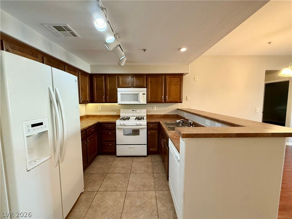 8777 W Maule Avenue, #1094, Las Vegas, NV 89148 Rich wood cabinetry paired with tiled flooring defines this functional and inviting culinary space.