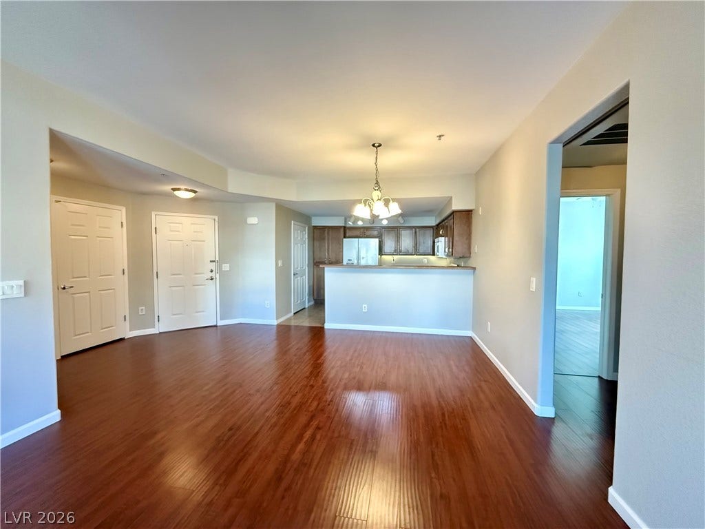 8777 W Maule Avenue, #1094, Las Vegas, NV 89148 Polished wood floors stretch across a versatile living area opening directly to the kitchen.