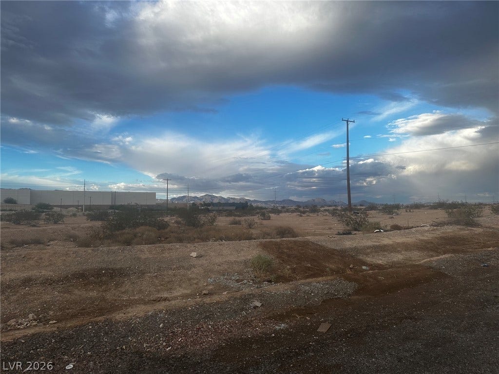 0 Reverend Wilson Ave, North Las Vegas, NV 89030 Dramatic desert skies open up over a vast acreage parcel showcasing scenic mountain views.