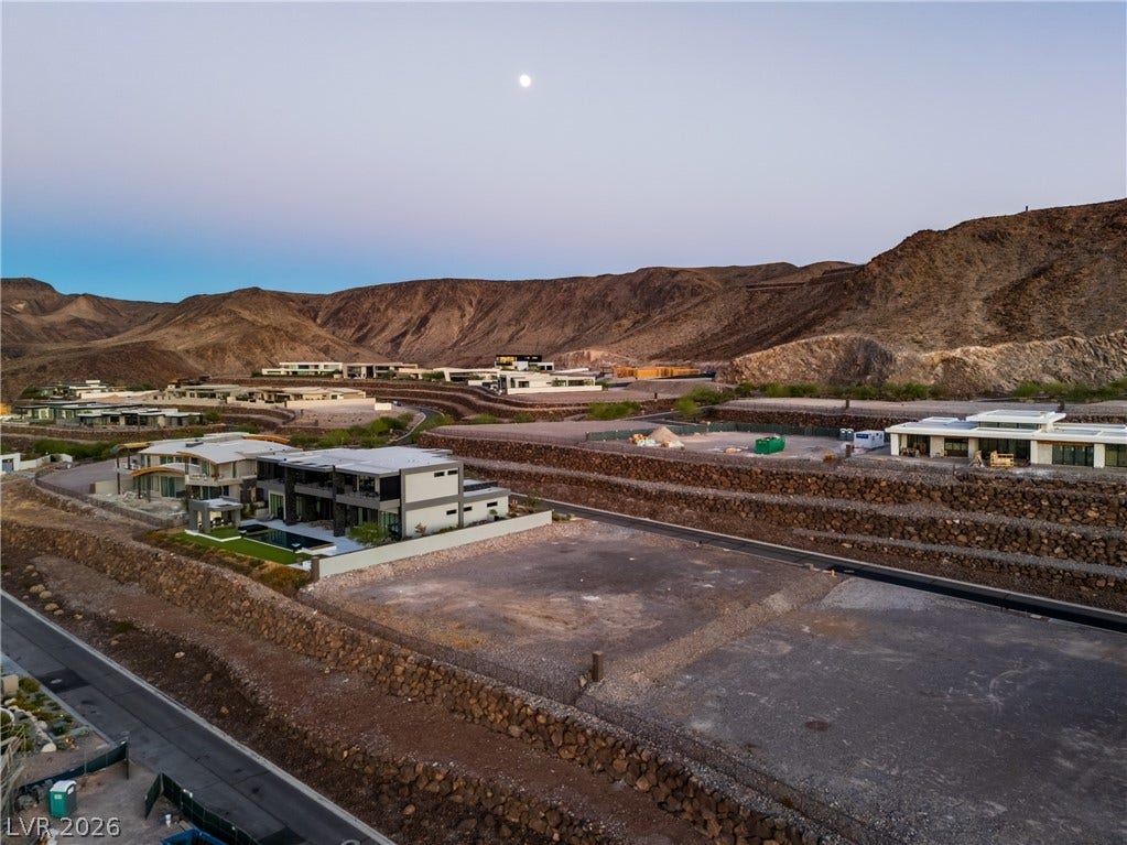 7 Sunset Strip, Henderson, NV 89012 Dramatic mountain vistas frame modern desert estates nestled along terraced hillsides under twilight skies.