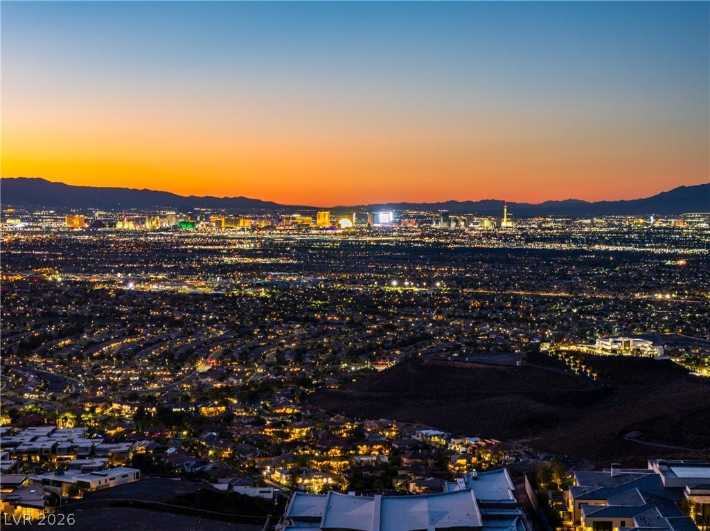 7 Sunset Strip, Henderson, NV 89012 Vibrant sunset skies frame the sweeping city lights and distant mountain peaks.