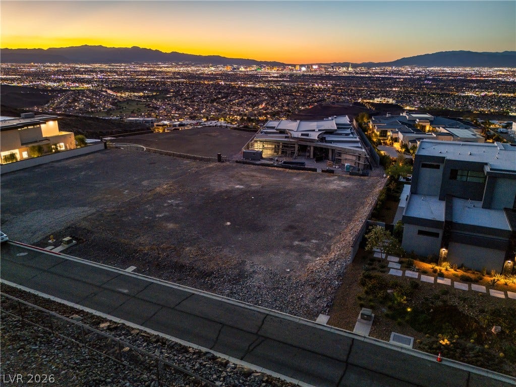 7 Sunset Strip, Henderson, NV 89012 An elevated building site overlooks glittering city lights against a dramatic mountain backdrop.