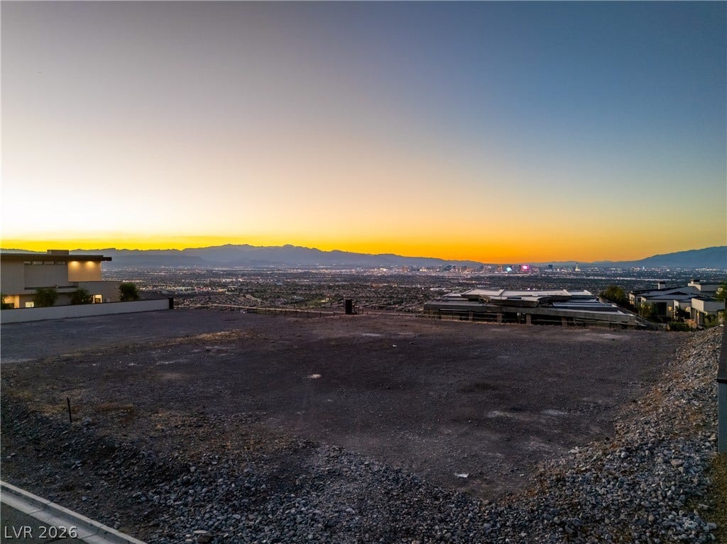 7 Sunset Strip, Henderson, NV 89012 Panoramic mountain and sparkling city views frame this elevated dirt building lot at twilight.