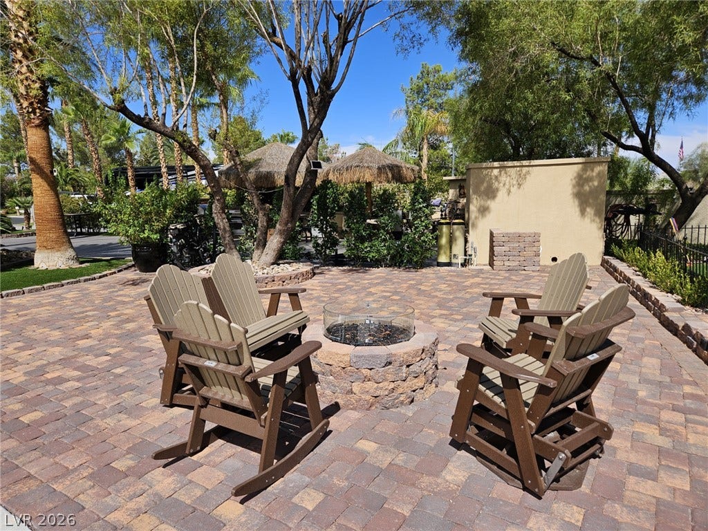 8175 Arville Street, #33, Las Vegas, NV 89139 Custom stone pavers surround a built-in fire pit framed by mature desert landscaping.