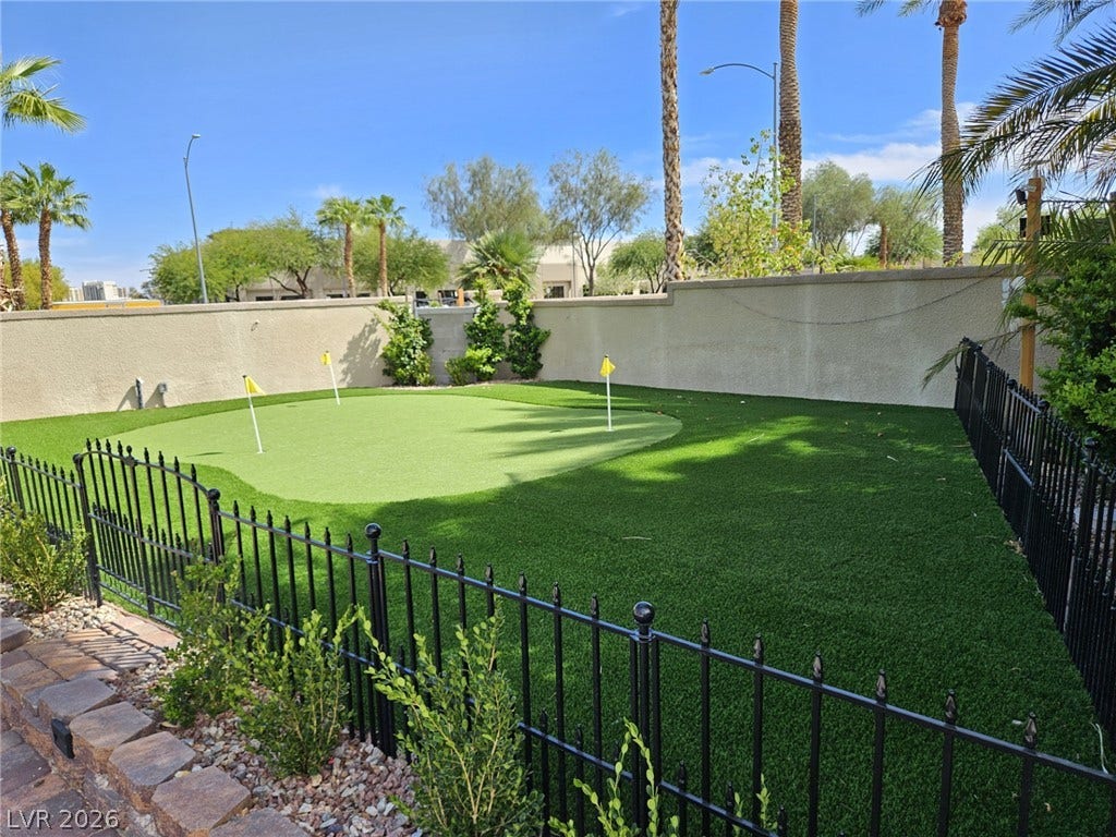 8175 Arville Street, #33, Las Vegas, NV 89139 A private backyard putting green offers recreational leisure beneath towering palm trees.