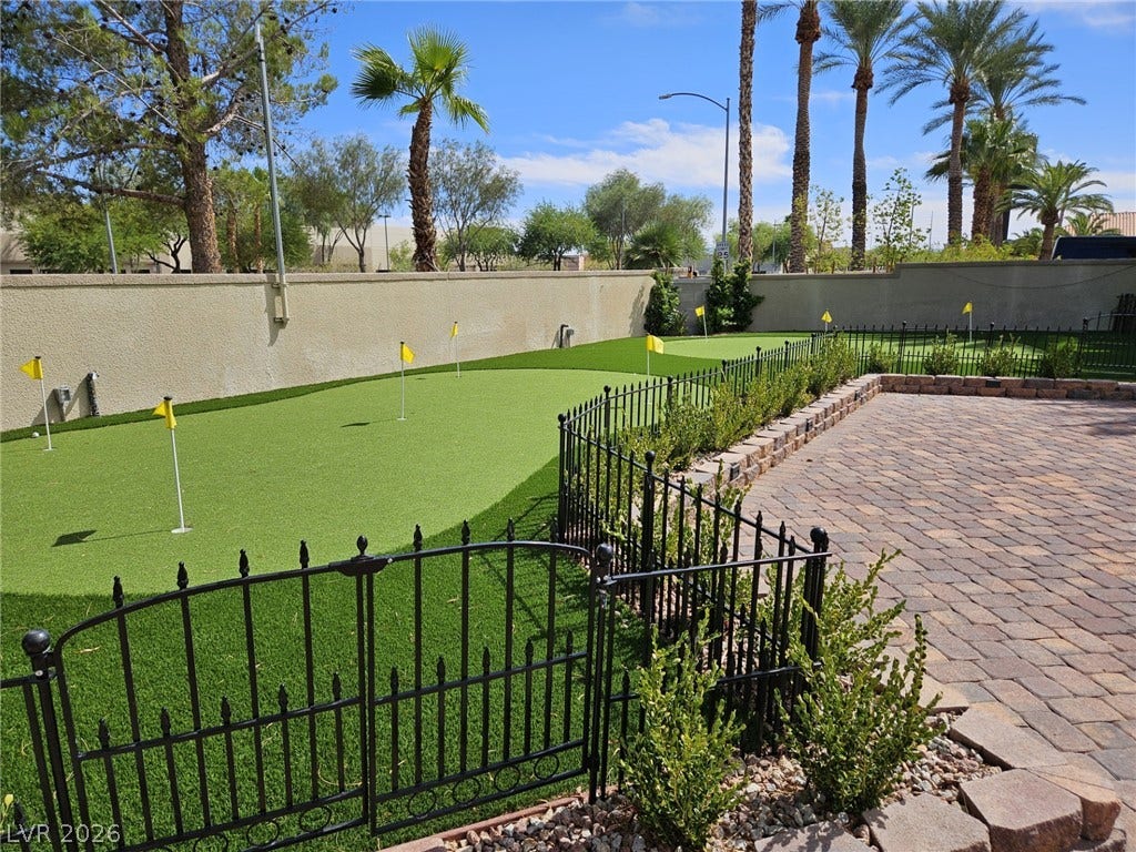 8175 Arville Street, #33, Las Vegas, NV 89139 An inviting paver patio opens to a private putting green bordered by elegant wrought iron fencing.