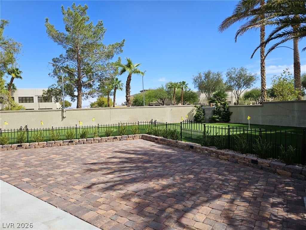 8175 Arville Street, #33, Las Vegas, NV 89139 An inviting stone paver patio opens to a manicured putting green under clear desert skies.
