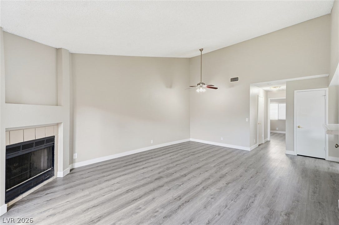 830 N Sloan Lane, #202, Las Vegas, NV 89110 Vaulted ceilings soar over a corner fireplace and modern wood-look flooring.