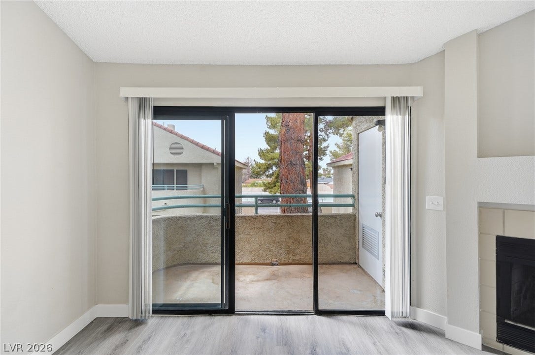 830 N Sloan Lane, #202, Las Vegas, NV 89110 Sliding glass doors open from the living area to a private balcony.