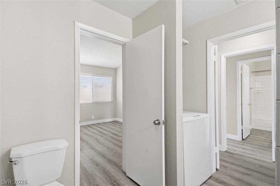 830 N Sloan Lane, #202, Las Vegas, NV 89110 Consistent vinyl plank flooring connects the bathroom, bedroom, and utility spaces seamlessly.