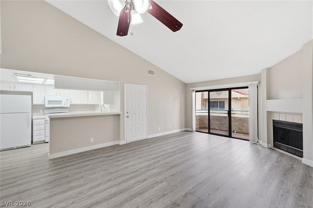 830 N Sloan Lane, #202, Las Vegas, NV 89110 Vaulted ceilings soar over durable vinyl flooring and a cozy fireplace in this open living area.