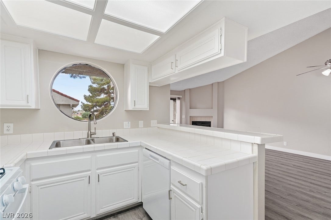 830 N Sloan Lane, #202, Las Vegas, NV 89110 An architectural round window frames outdoor views in this functional, bright kitchen space.