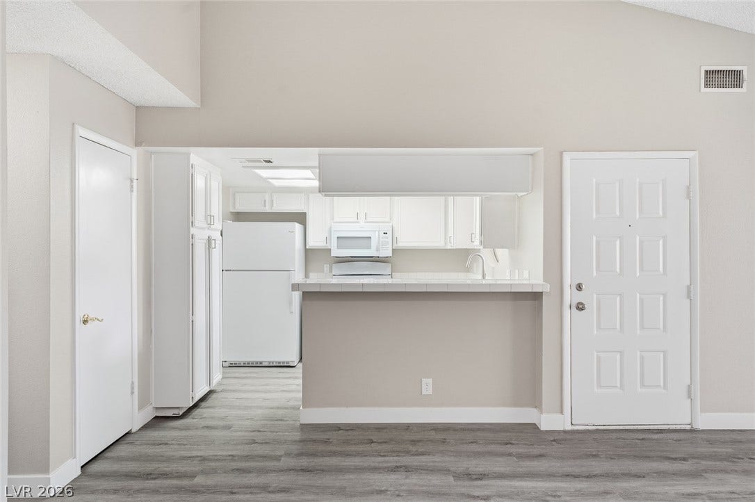830 N Sloan Lane, #202, Las Vegas, NV 89110 An open floorplan seamlessly connects the living space to the kitchen under high vaulted ceilings.