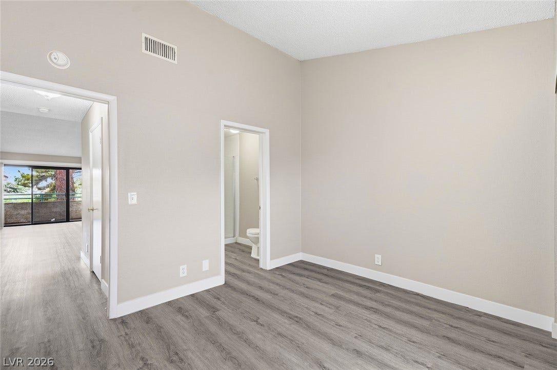 830 N Sloan Lane, #202, Las Vegas, NV 89110 Vaulted ceilings and wood-look flooring enhance this light-filled room with direct bathroom access.