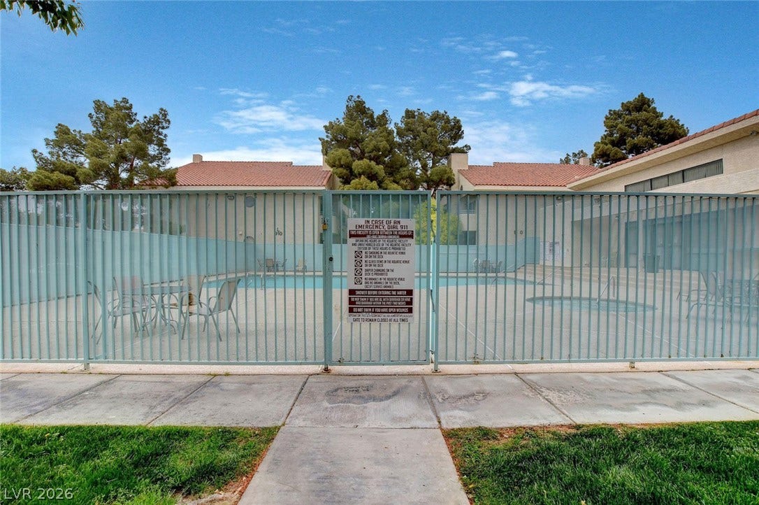 830 N Sloan Lane, #202, Las Vegas, NV 89110 An enclosed community swimming pool area is secured by metal fencing.