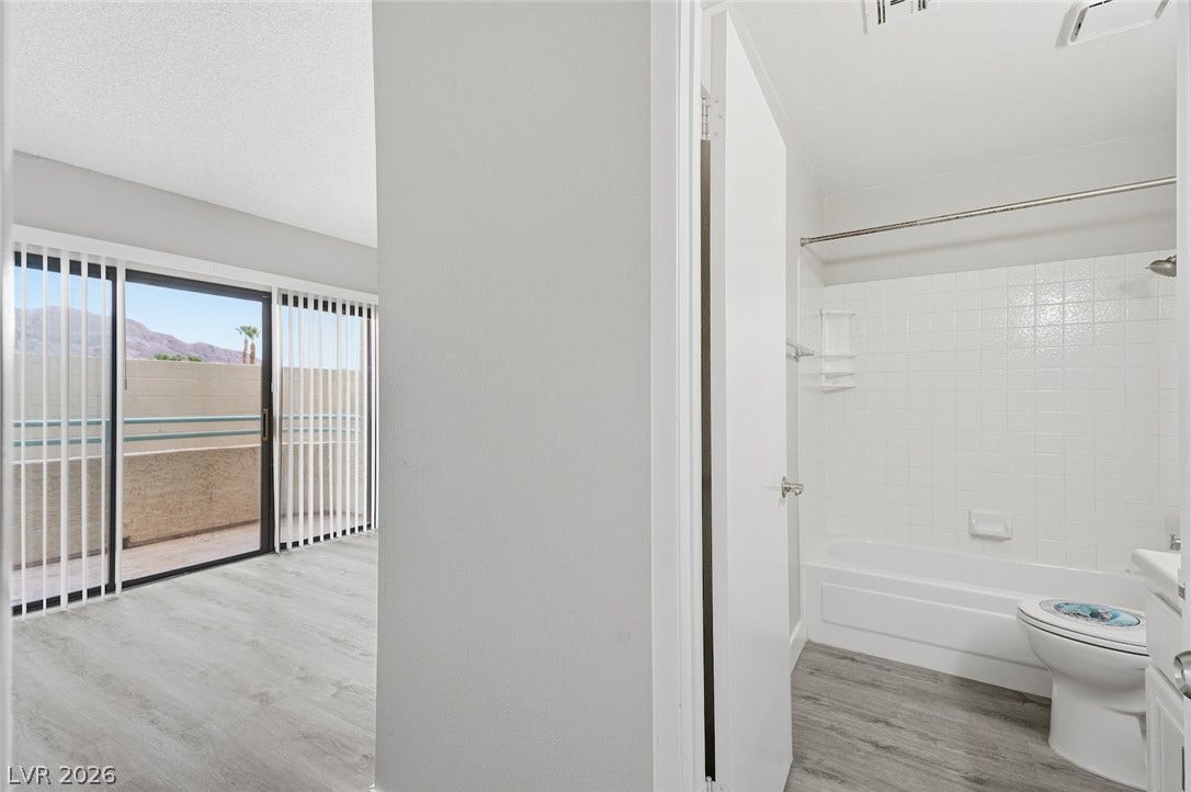 830 N Sloan Lane, #202, Las Vegas, NV 89110 An open layout connects the living space and private bathroom featuring modern wood-plank flooring.