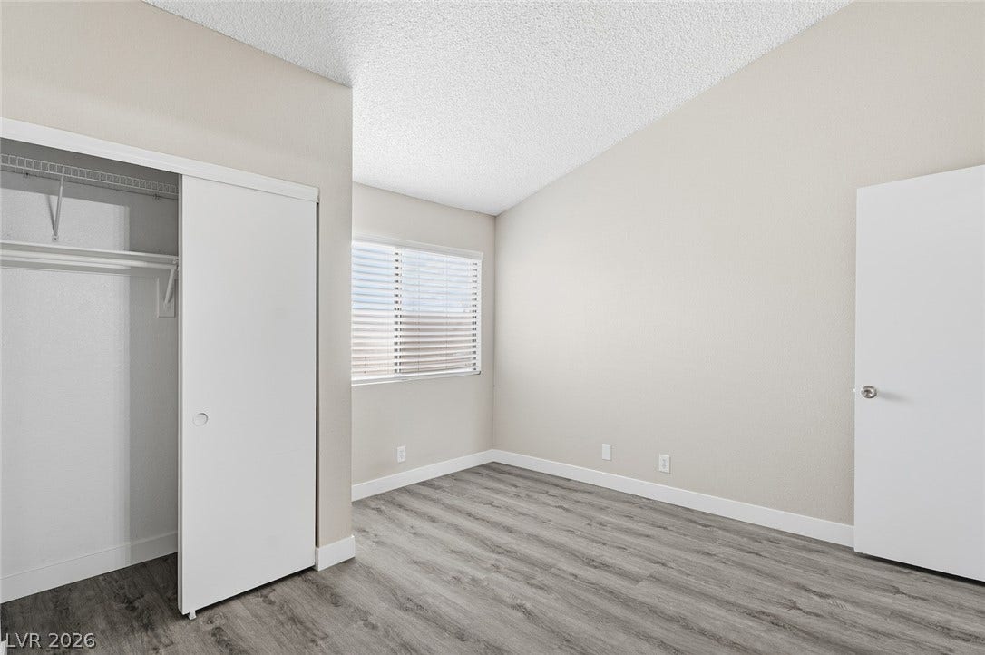 830 N Sloan Lane, #202, Las Vegas, NV 89110 Vaulted ceilings and wood-style flooring elevate this comfortable bedroom space.