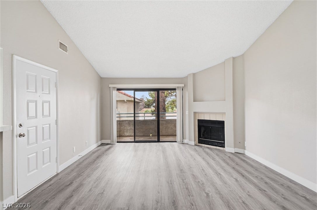 830 N Sloan Lane, #202, Las Vegas, NV 89110 Sliding glass doors open to a private balcony in this fireplace-warmed living room.