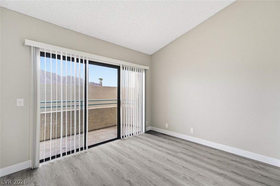 830 N Sloan Lane, #202, Las Vegas, NV 89110 Sliding glass doors open to a private balcony under soaring vaulted ceilings.