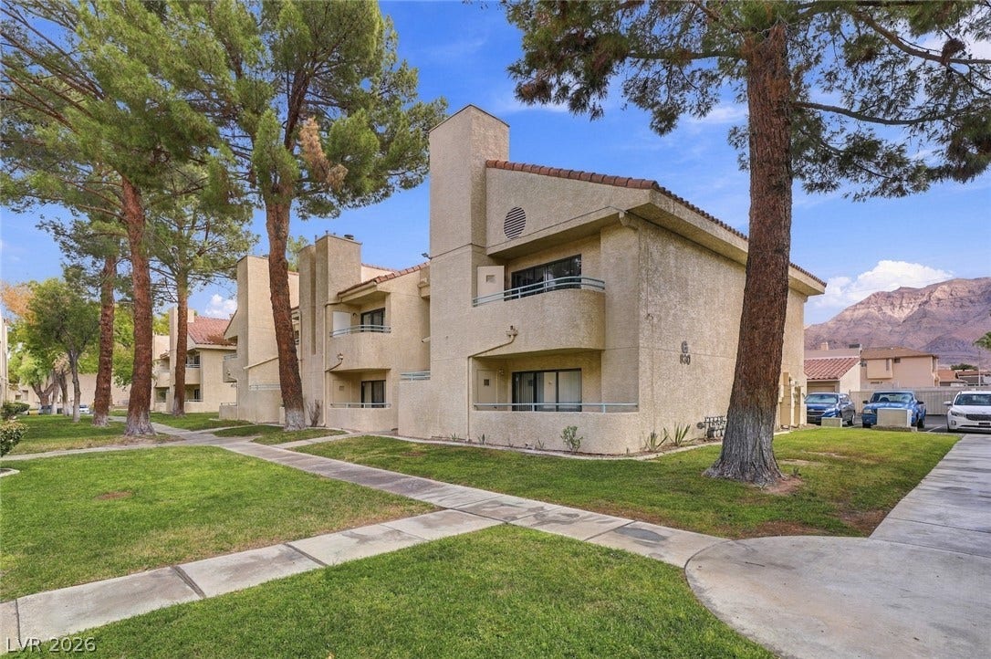 830 N Sloan Lane, #202, Las Vegas, NV 89110 Mature trees shade the concrete walkways leading to this classic multi-level stucco exterior.