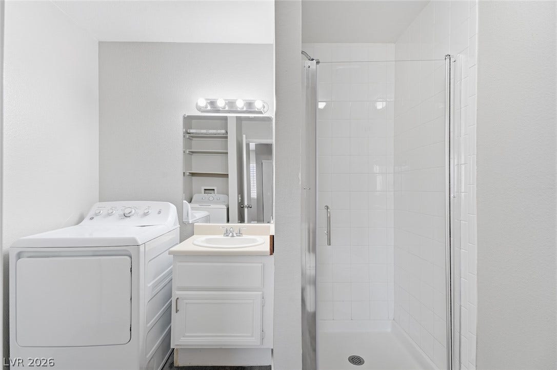 830 N Sloan Lane, #202, Las Vegas, NV 89110 A glass-enclosed walk-in shower complements this compact bathroom setup featuring in-room laundry installations.