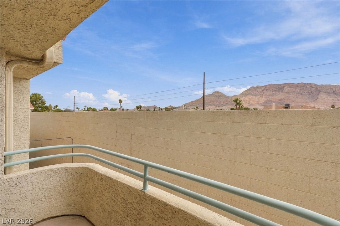 830 N Sloan Lane, #202, Las Vegas, NV 89110 Rugged mountain views rise above the privacy wall of this stucco balcony.