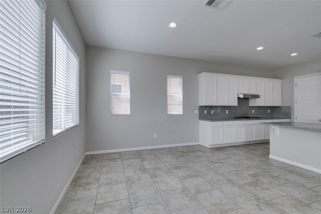 An open kitchen and dining layout highlights durable tile flooring and recessed lighting.