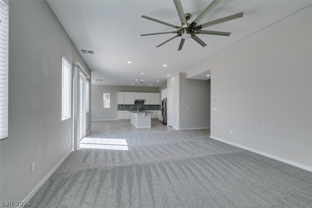 An open layout connects the carpeted living space directly to the kitchen area.