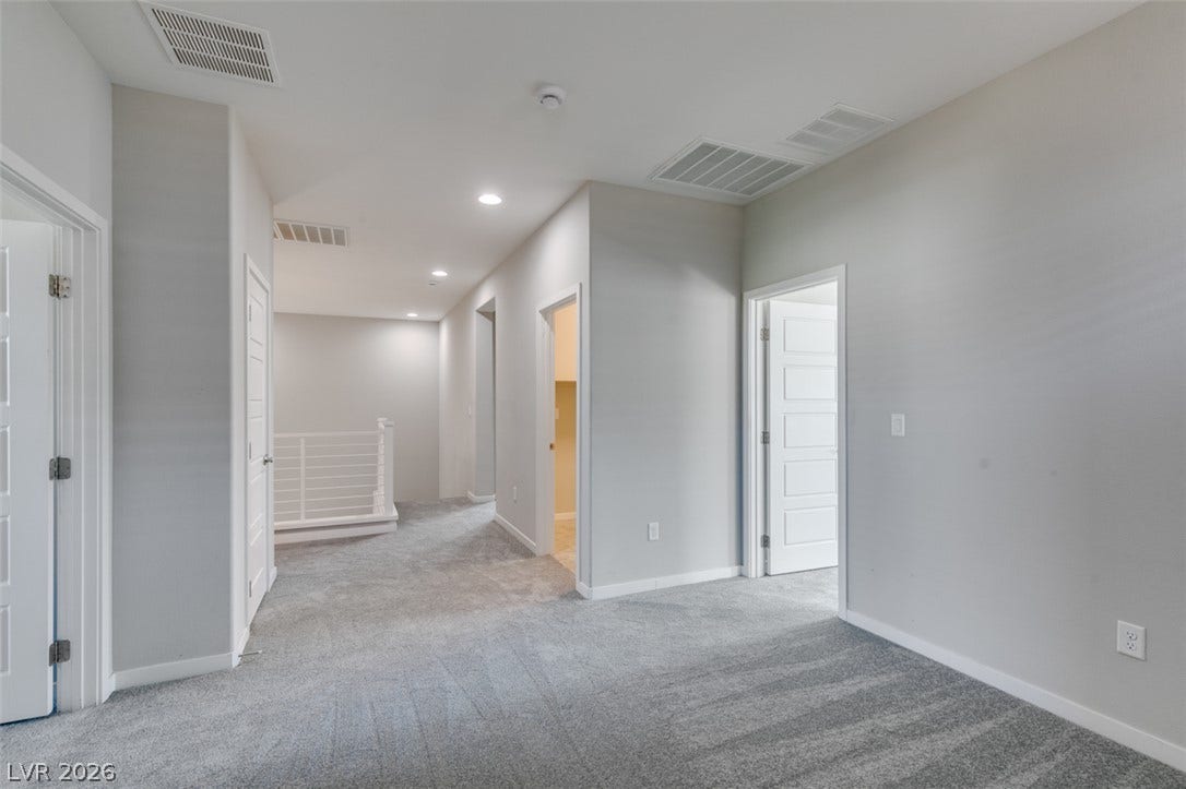 A spacious upper-level landing features soft wall-to-wall carpeting and neutral walls throughout.