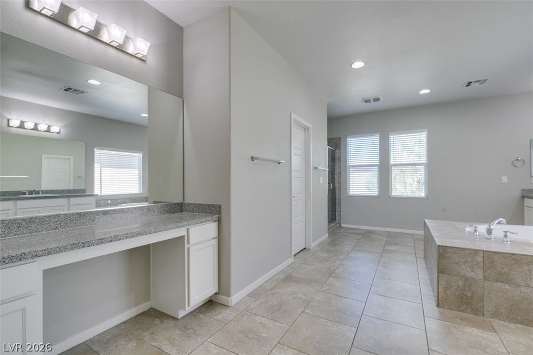 Clean tile flooring and stone counters define this master bathroom design.
