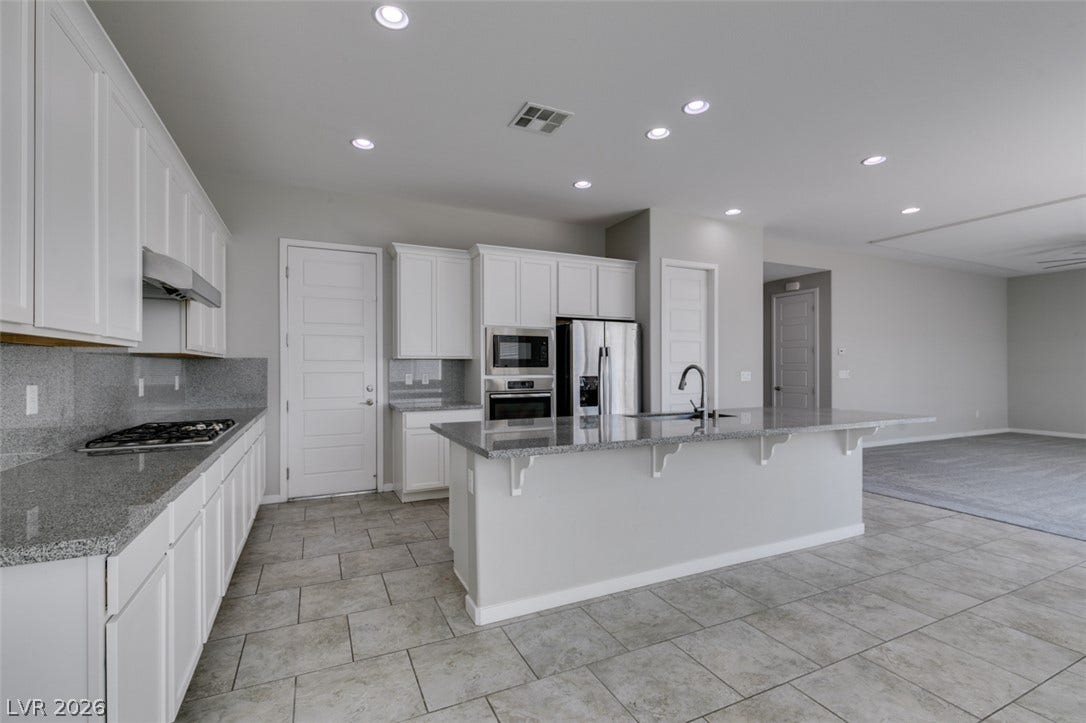 An open floorplan connects the modern kitchen directly to adjacent living spaces.