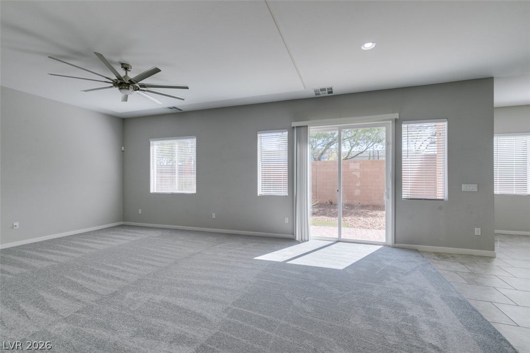 Sliding glass doors open from this carpeted living area to the backyard patio.