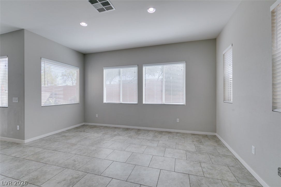 Ample natural light fills this versatile space finished with large-format tile flooring.