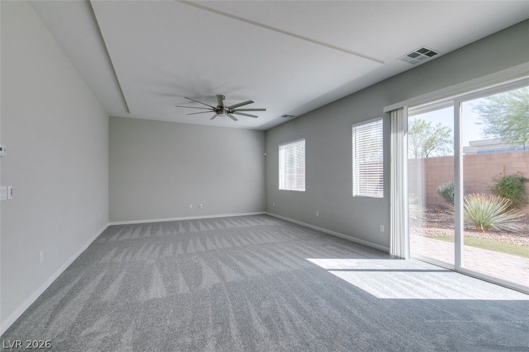 Sliding glass doors open directly to the backyard from this carpeted living area.