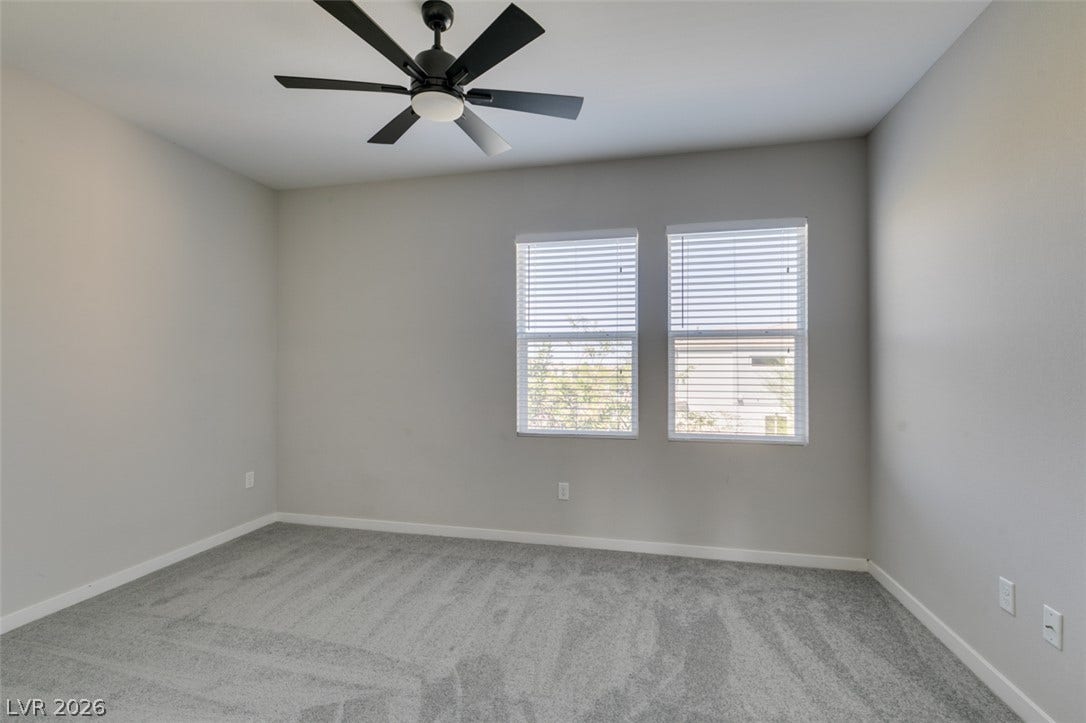 Plush wall-to-wall carpeting and twin windows frame this comfortable secondary bedroom.