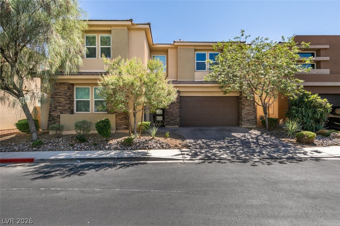 Stone accents and desert landscaping complement this modern two-story home with a two-car garage.