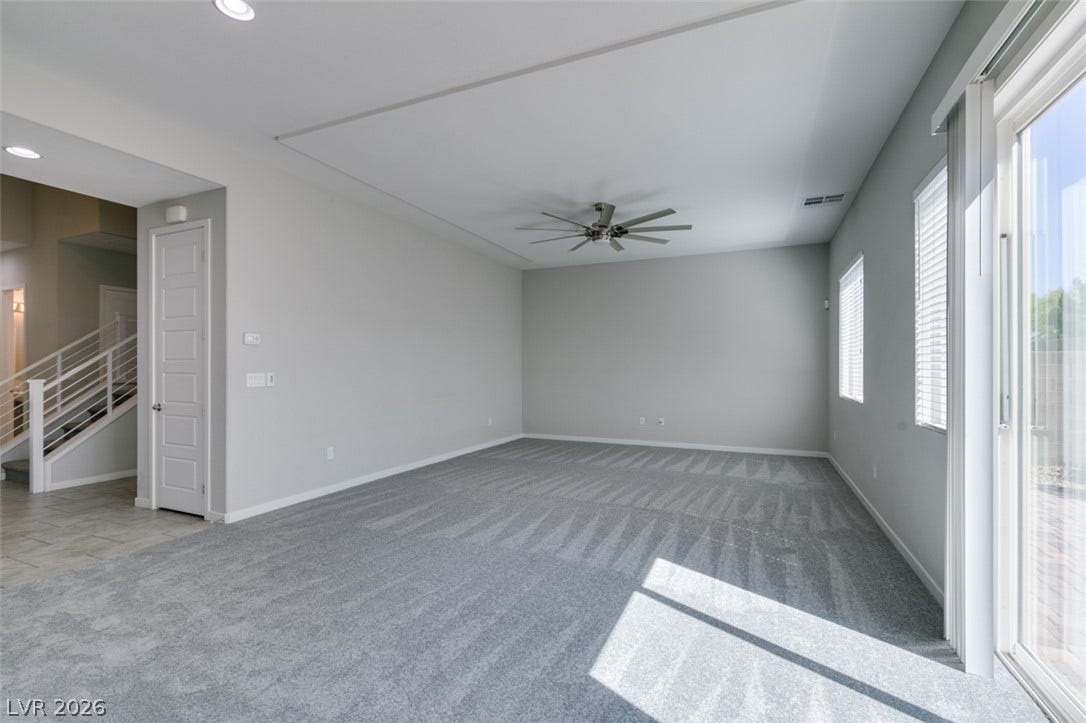 Sliding glass doors open from a spacious carpeted living area to the backyard.